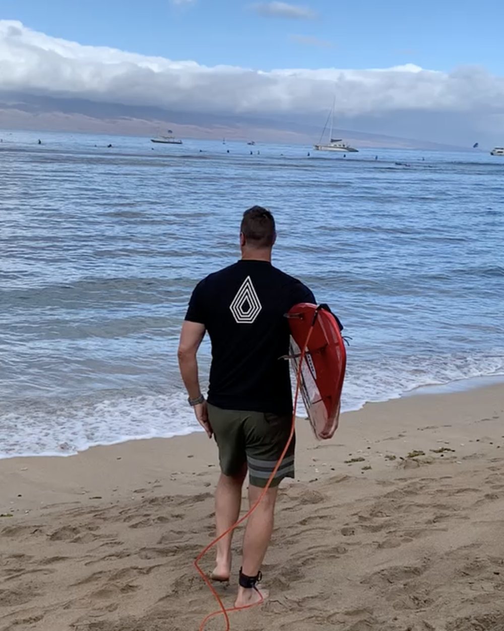 Todd Shea walking into the water with a board