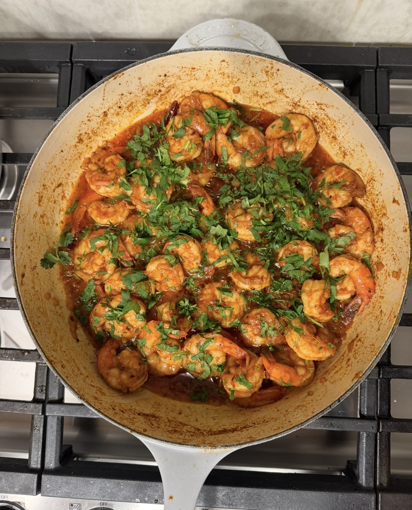Camarones al mojo de ajo in a pan, garnished with cilantro