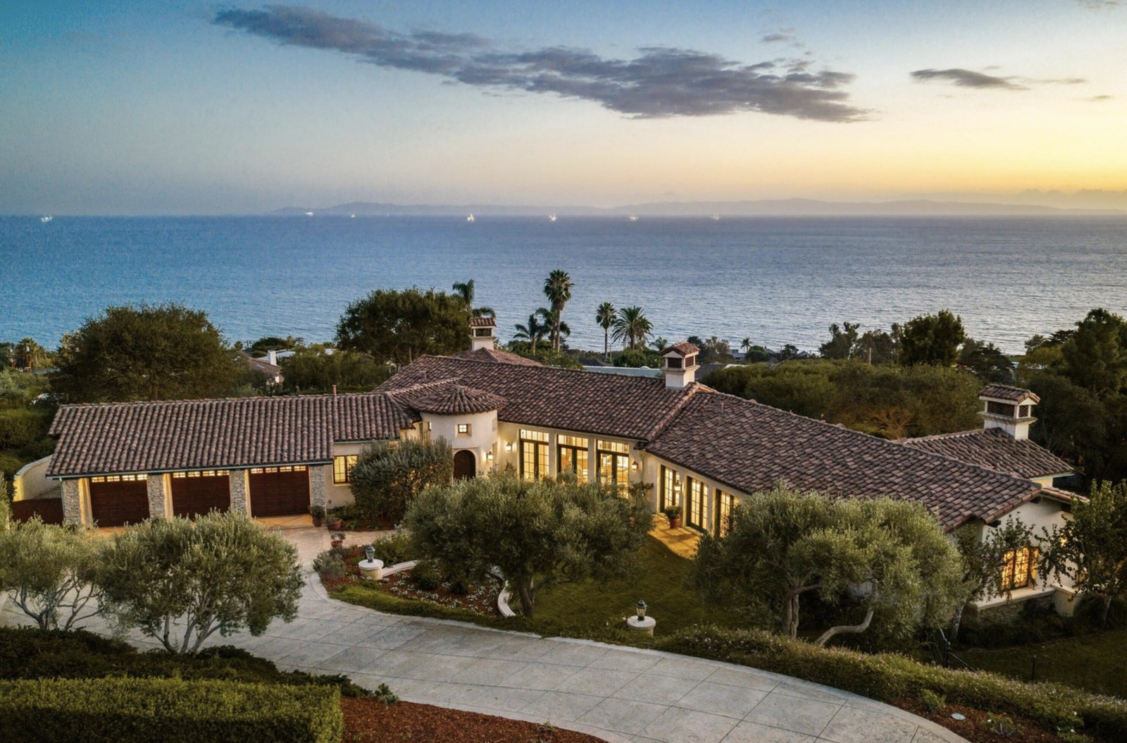 Aerial view of the Spanish estate at 2315 Ortega Ranch Road at sunset, with the ocean and Channel Islands behind it